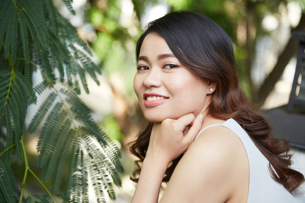 Jonge aantrekkelijke lachende Vietnamese brunette buiten rusten - Foto, afbeelding