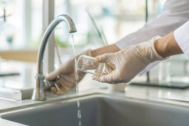 Wissenschaftler waschen Becher nach Experimenten von giftiger Säure - Foto, Bild