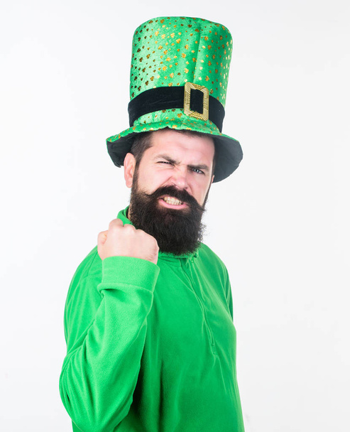 The power of the irish. Irish man with beard flexing his arm. Happy saint patricks day. Bearded man celebrating saint patricks day. Hipster in green leprechaun hat and costume - 写真・画像