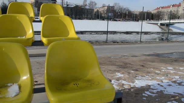 κίτρινο καρέκλες και πλωτή πάγου στον ποταμό την πρώτη άνοιξη ημέρες - Πλάνα, βίντεο