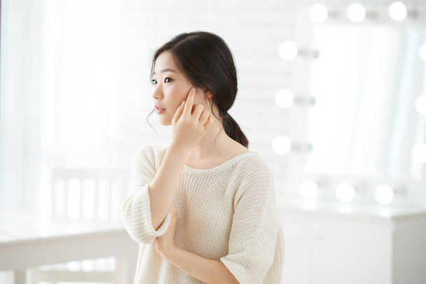 Piękna dziewczyna koreański dotykając miękkiej skóry twarzy z palca - Zdjęcie, obraz