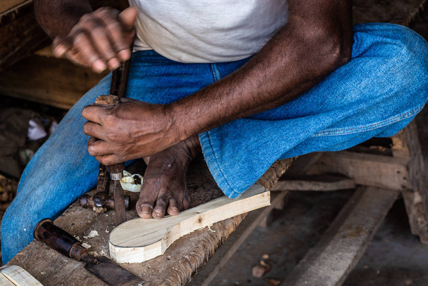 houtbewerker die met handgereedschap bewerkt houten lepel met houtsnijmessen - Foto, afbeelding