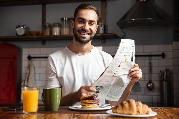 Smiling man having breakfast - Fotó, kép