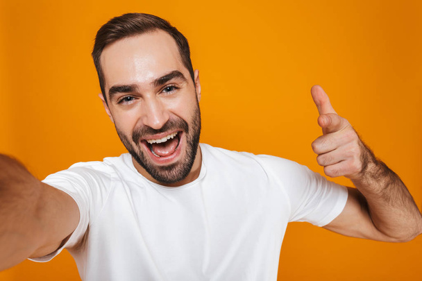 Portrait of successful man 30s in t-shirt laughing while taking  - Foto, Imagem