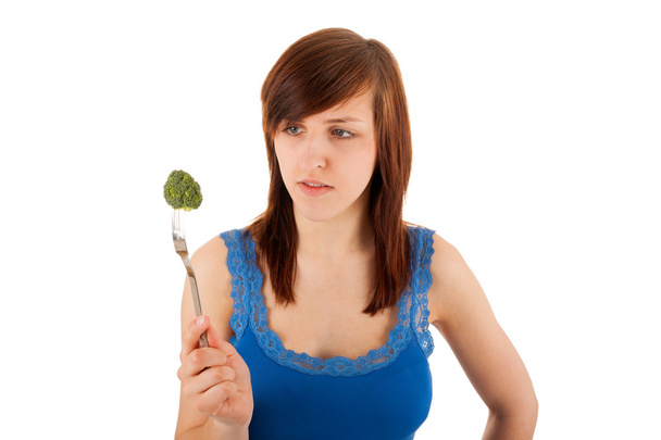 The young woman with a piece of broccoli on her fork - Foto, immagini