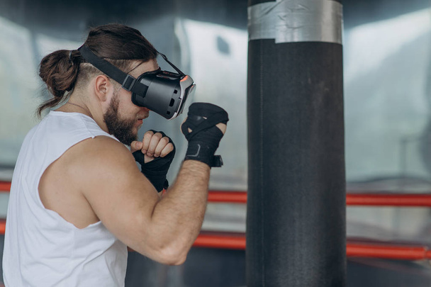 Muscular boxer man with vr glasses fighting in simulated virtual reality - Foto, Imagen