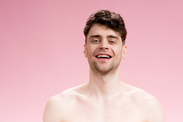 good-looking, smiling brunette man looking at camera on pink - Photo, image