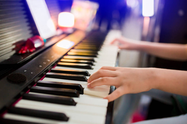Closeup kid's hand pianospelen op het podium - Foto, afbeelding