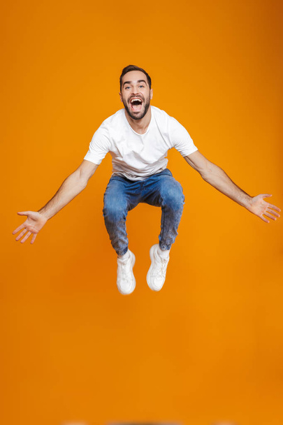 Full length photo of handsome guy in t-shirt and jeans jumping a - Foto, imagen