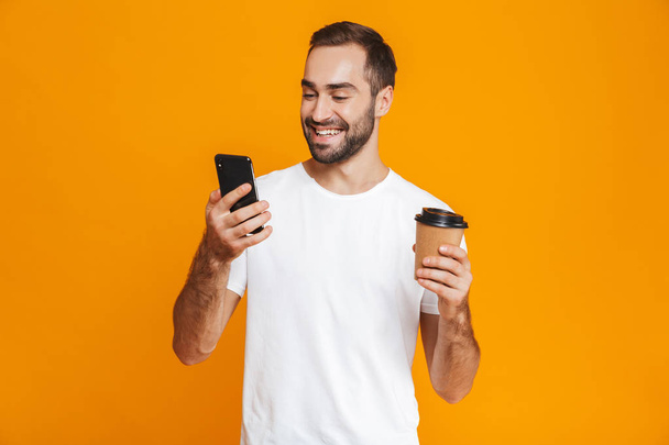 Photo of beautiful man 30s in casual wear holding cell phone and - Φωτογραφία, εικόνα