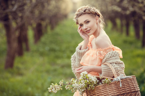 Красивая молодая девушка в старом платье в цветущем груше саду
. - Фото, изображение