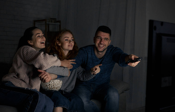 Szczęśliwy przyjaciółmi, oglądając telewizję i przełączania kanałów - Zdjęcie, obraz