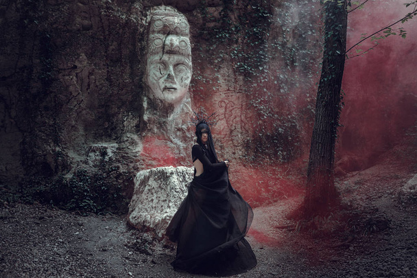 Красивая женщина с бледной кожей в черном платье и в черной короне. Готический вид. Наряд на Хэллоуин
. - Фото, изображение