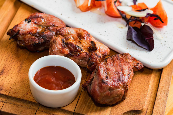 Baharatlar, sebze ve ahşap tahta ketçap ile kavrulmuş domuz eti boyun kadar kapatın - Fotoğraf, Görsel