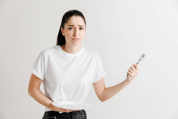 Giovane divertimento pazzo bruna casalinga con forchetta isolato su sfondo bianco
 - Foto, immagini