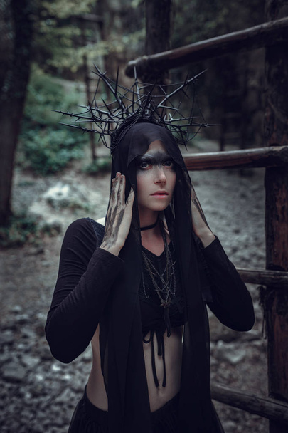 A woman is a prophet sorcerer and a preacher in a black mystical cloak - Foto, Imagen