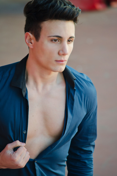Handsome young man standing with open shirt showing torso - Foto, Bild
