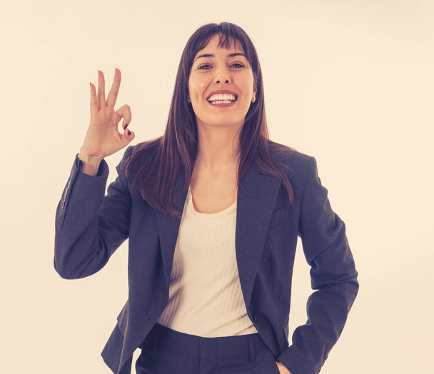 Half length portrait of young pretty business woman standing and making all OK gesture. Smiling feeling confident and successful. In people business education, success and work environment concept. - Foto, imagen