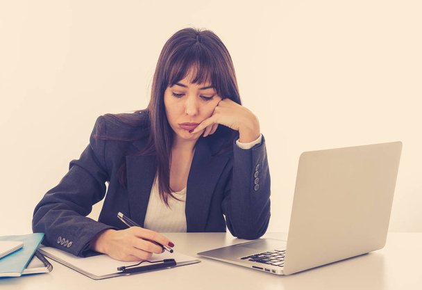 Young beautiful business woman suffering stress working on laptop at office computer desk feeling tired and frustrated looking overworked and overwhelmed. In business education, failure technology. - 写真・画像