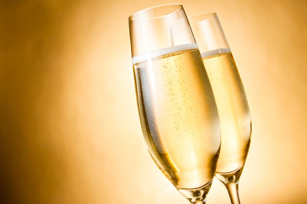 two glasses of champagne with golden bubbles and space for text - Foto, imagen