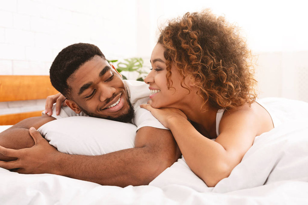 Αγαπώντας μαύρο ζευγάρι χαλαρώνοντας στο κρεβάτι στο σπίτι - Φωτογραφία, εικόνα