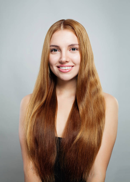 Jonge mooie lachende vrouw met gezonde natuurlijke haren op wit - Foto, afbeelding