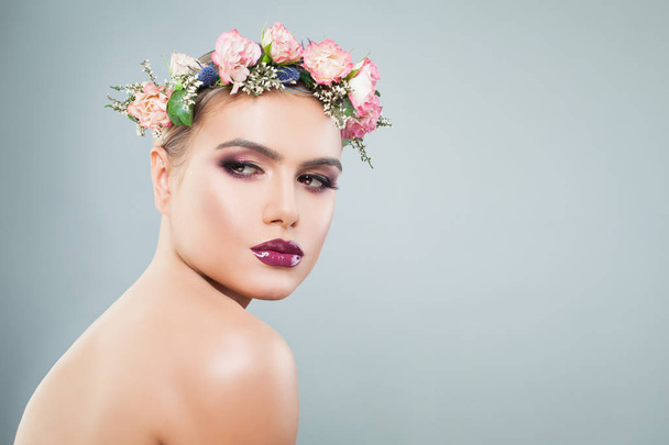 Beautiful woman with colorful makeup in wreath of flowers - Zdjęcie, obraz