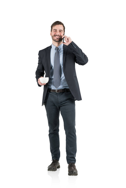 Smiling businessman with coffee on phone, isolated - Foto, immagini