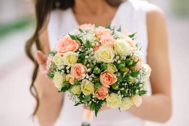 wedding bouquet with peach roses in the hands of the bride. close up - Фото, зображення