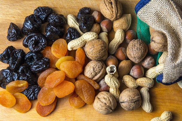 χορτοφαγικά τρόφιμα των ξηρών καρπών και αποξηραμένων φρούτων στον πίνακα κουζινών - Φωτογραφία, εικόνα