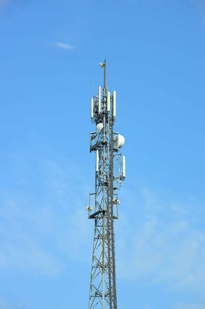 Radyo kulesi antenler bir mavi gökyüzü arka plan ile. Metal konstrüksiyon. Kablosuz ağ. TV radyo sinyali iletmek. Egology çevre. Bilgi dijitalleştirme ve yüksek teknoloji - Fotoğraf, Görsel