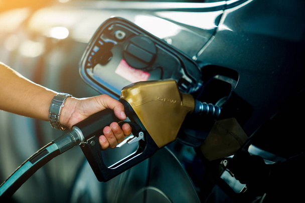 Hand refilling the car with fuel at the refuel station - Photo, Image