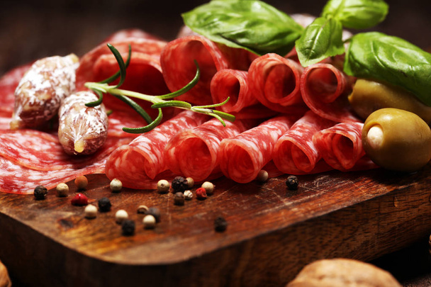 thinly sliced salami on a wooden texture on the background. - 写真・画像
