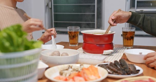 Asian couple eat hot pot together at home - 写真・画像