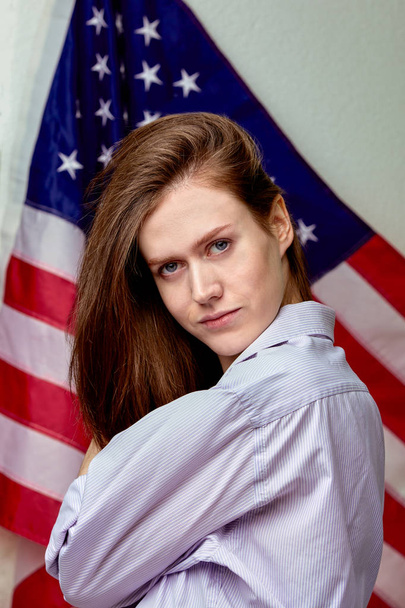 Portrait of beautiful girl in shirt on american flag background close up - 写真・画像