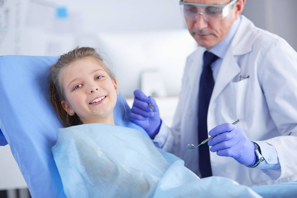 Little girl sitting in the dentists office - Photo, image