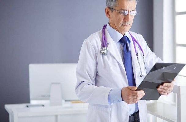 Mužský lékař píše poznámky do schránky v nemocnici - Fotografie, Obrázek