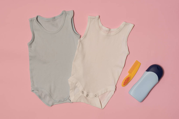 bodysuit bebê azul e branco em um fundo rosa. Acessórios. Conceito de moda
 - Foto, Imagem