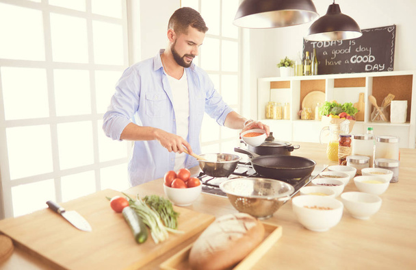 Mann bereitet leckeres und gesundes Essen in der heimischen Küche zu - Foto, Bild