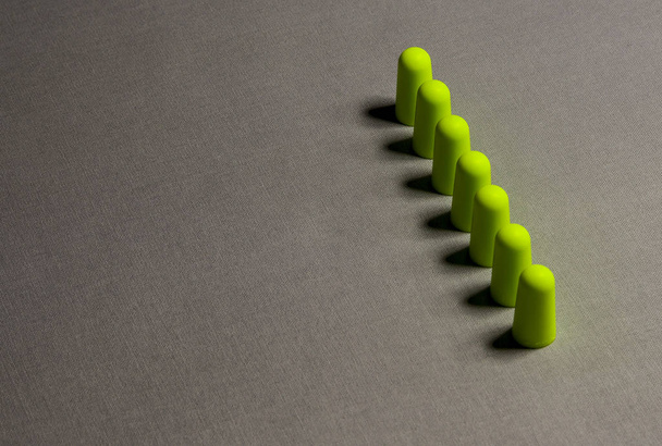 Green earplugs on a gray background-image - Fotó, kép