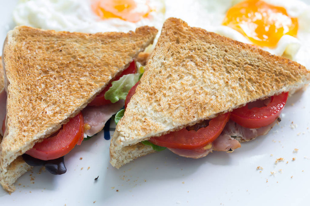 Sandwich con jamón y tomate en plato
 - Foto, imagen