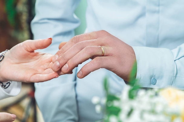 Groom with a wedding ring on his finger gently touches the hand of the bride - Φωτογραφία, εικόνα
