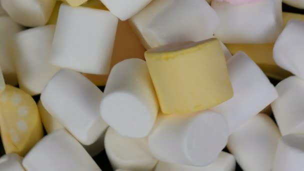 Multicolore mini marshmallow caramelle rotazione lentamente sulla superficie dello specchio e uno sfondo nero vista dall'alto. Il problema del diabete e mangiare troppo dolce
. - Filmati, video