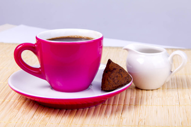 Espresso kahve parlak pembe seramik Kupası ve bitter çikolata bir fincan tabağı üzerinde gelen şeker bölümü sürahi için krem yakınındaki olmak - Fotoğraf, Görsel