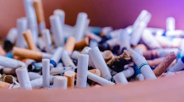 cigarrillo a tope cigarrillo en el cenicero con arena y estuche de cigarrillo
 - Foto, Imagen