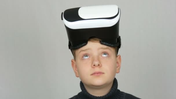 Tiener jongen met Virtual Reality of VR bril op zijn hoofd en plezier op een witte achtergrond in de Studio - Video