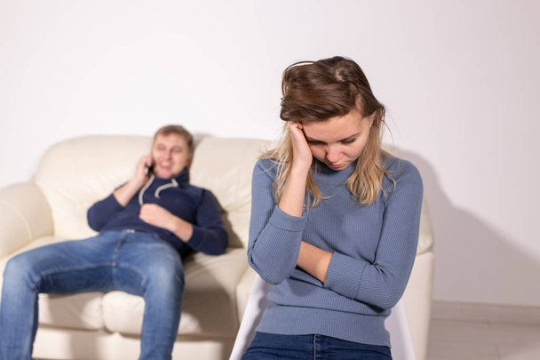 huiselijk geweld, mishandeling en familie concept - huilen vrouw en haar man op de achtergrond - Foto, afbeelding