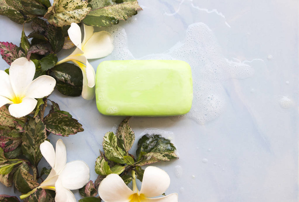 Herbal zeep lichaam wassen gladde huid met Soapsuds voor gezondheidszorg lichaam huid en witte bloem Frangipani decoratie op tie  - Foto, afbeelding