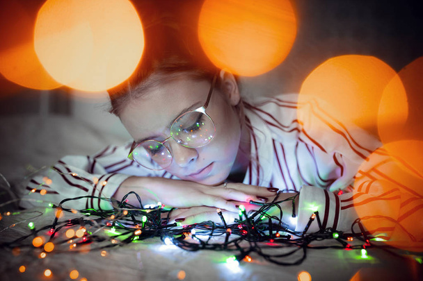Young woman with fairy lights dreaming in bed - Foto, Bild