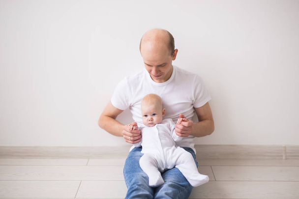 Csecsemő, a család és a gyermekek koncepció - portré egy kislánya apák karjaiban közelről - Fotó, kép